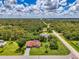 Sweeping aerial view of a red roof home surrounded by lush trees, showcasing its location at 510 Border St, Port Charlotte, FL 33953