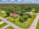 Wide aerial view showcasing a home with a red tile roof, screened pool, and lush green surroundings at 510 Border St, Port Charlotte, FL 33953