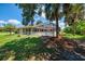 Backyard showcasing the screened pool enclosure, lush landscaping, and a well-maintained lawn, perfect for outdoor living at 510 Border St, Port Charlotte, FL 33953