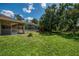 Expansive backyard with lush green grass, a screened pool enclosure, and mature trees providing shade and privacy at 510 Border St, Port Charlotte, FL 33953
