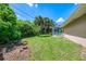 Well-manicured backyard featuring tropical palm trees, green grass, and a glimpse of the screened pool enclosure at 510 Border St, Port Charlotte, FL 33953