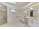 Bright bathroom featuring a tub, glass-door shower and dual sinks with vanity at 510 Border St, Port Charlotte, FL 33953