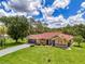 Beautiful one-story home with manicured lawn, attached two-car garage, and a long, gray driveway at 510 Border St, Port Charlotte, FL 33953