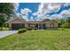Well-kept home with a dark garage door, manicured bushes, and a green lawn leading to a gray driveway at 510 Border St, Port Charlotte, FL 33953