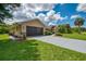 Charming home featuring an attached two-car garage, manicured lawn, and lush landscaping for curb appeal at 510 Border St, Port Charlotte, FL 33953