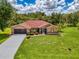 Charming single-story home boasts a well-manicured lawn, beautiful landscaping, and a screened front entry at 510 Border St, Port Charlotte, FL 33953