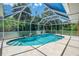 Sparkling in-ground pool within a screened enclosure, framed by lush tropical foliage at 510 Border St, Port Charlotte, FL 33953