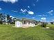 Back exterior view of the house with lush green grass, a patio and a small shed at 6562 Hikina Dr, North Port, FL 34287