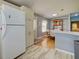View of kitchen and dining areas featuring white cabinets, modern appliances, and stylish flooring at 6562 Hikina Dr, North Port, FL 34287