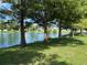 Scenic view of a serene pond lined with lush trees and greenery in a peaceful setting at 6562 Hikina Dr, North Port, FL 34287