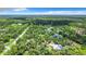 Idyllic aerial shot of a home surrounded by lush landscaping and beautiful mature trees at 6594 Buckboard St, North Port, FL 34291
