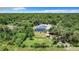 Aerial shot of the home with a pool and solar panels surrounded by lush greenery at 6594 Buckboard St, North Port, FL 34291