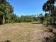 Open and expansive backyard featuring a mix of grass and clear land at 6594 Buckboard St, North Port, FL 34291