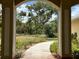 Framed view of a picturesque backyard with a stone path and lush trees at 6594 Buckboard St, North Port, FL 34291