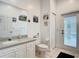 Cozy bathroom featuring a vanity with a sink, toilet, and a door that provides access to the outside at 6594 Buckboard St, North Port, FL 34291