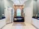 Bright bathroom with a soaking tub, a walk-in shower, double sinks, and neutral tile flooring at 6594 Buckboard St, North Port, FL 34291