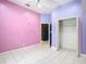 Bright bedroom with tile floors, a ceiling fan, closet and pink and purple painted walls at 6594 Buckboard St, North Port, FL 34291