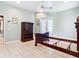 Well-lit bedroom with tiled floors, French doors, and a traditional wooden bed frame at 6594 Buckboard St, North Port, FL 34291