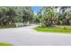 View of a gated entrance and driveway surrounded by lush trees and landscaping at 6594 Buckboard St, North Port, FL 34291