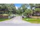 Long private driveway with a gate entrance surrounded by mature trees at 6594 Buckboard St, North Port, FL 34291