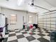 Spacious garage with checkered flooring and an automatic door, ideal for vehicle storage or workshop at 6594 Buckboard St, North Port, FL 34291