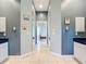 Hallway with neutral tile flooring and pastel walls leading to other areas of the home at 6594 Buckboard St, North Port, FL 34291