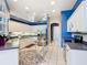 Modern kitchen with white cabinets, stainless steel appliances, and blue accent walls at 6594 Buckboard St, North Port, FL 34291