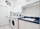 Laundry room featuring a white washer and dryer, utility sink, and white cabinets at 6594 Buckboard St, North Port, FL 34291