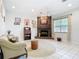 Cozy living room with a brick fireplace, neutral-toned decor, and tiled flooring at 6594 Buckboard St, North Port, FL 34291