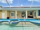 Beautiful pool area with hot tub, solar panels, and covered patio at 6594 Buckboard St, North Port, FL 34291