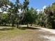 Scenic view of the expansive yard and driveway surrounded by mature trees at 6594 Buckboard St, North Port, FL 34291