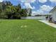 Large backyard with lush green grass, privacy fencing, and a patio area at 724 Hartford Nw Dr, Port Charlotte, FL 33952
