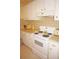 Retro kitchen features white cabinets and appliances, including an electric range, and vintage countertop appliances at 724 Hartford Nw Dr, Port Charlotte, FL 33952