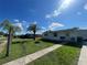 Single-story home with a well-maintained lawn and a variety of beautiful palm trees at 2336 Picnic St, Port Charlotte, FL 33952