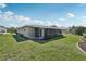 Lush backyard featuring a screened-in patio, well-manicured lawn, and landscaped garden beds at 1107 Seneca Rd, Venice, FL 34293