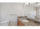 Bathroom vanity featuring granite countertop, wooden cabinets, and a large mirror at 1107 Seneca Rd, Venice, FL 34293