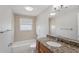 Bathroom featuring a granite vanity, combination shower and tub, and neutral tile at 1107 Seneca Rd, Venice, FL 34293