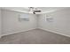 Neutral bedroom with a ceiling fan, two windows, and plush carpeting at 1107 Seneca Rd, Venice, FL 34293