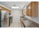Functional kitchen featuring stainless steel appliances, granite countertops, and wooden cabinetry, blending style and utility at 1107 Seneca Rd, Venice, FL 34293