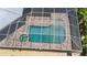 Aerial view of screened pool and spa with outdoor living area at 119 Creek Se Dr, Port Charlotte, FL 33952