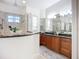Elegant bathroom featuring granite counters, travertine tile and dual shower heads at 119 Creek Se Dr, Port Charlotte, FL 33952