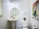 Well-lit bathroom with a pedestal sink, modern fixtures, and neutral décor at 119 Creek Se Dr, Port Charlotte, FL 33952
