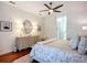 This bedroom has hardwood floors, a ceiling fan, dresser, and ensuite bathroom access at 119 Creek Se Dr, Port Charlotte, FL 33952