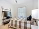 Bright bedroom features a comfortable bed with a decorative shelf and large window at 119 Creek Se Dr, Port Charlotte, FL 33952