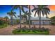 Stunning home featuring a spacious two-car garage, lush landscaping, and brick driveway at 119 Creek Se Dr, Port Charlotte, FL 33952