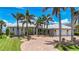 Beautiful home with lush landscaping and a spacious two-car garage with palm trees at 119 Creek Se Dr, Port Charlotte, FL 33952