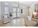Bright open foyer featuring tile flooring, statement light fixture, and glass paneled doors at 119 Creek Se Dr, Port Charlotte, FL 33952