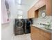 Efficient laundry room equipped with washer, dryer, sink, and custom cabinets at 119 Creek Se Dr, Port Charlotte, FL 33952