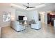 Inviting living room featuring neutral tones, tile flooring, and a decorative tray ceiling with fan at 119 Creek Se Dr, Port Charlotte, FL 33952