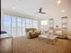 Comfortable living room with sliding glass doors showcasing water views, neutral decor, and ceiling fan at 119 Creek Se Dr, Port Charlotte, FL 33952